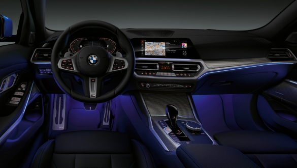 Седан BMW 3 серии, подсветка Ambient light Вид спереди места водителя седана BMW 3 серии с подсветкой Ambient light синего цвета пространства для ног.