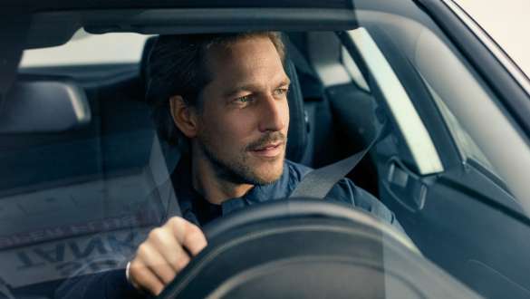 Мужчина за рулем BMW Мужчина за рулем BMW смотрит сквозь лобовое стекло