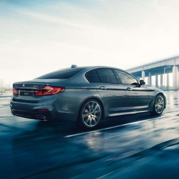 BMW 5 серия Седан, вид сзади с поворотом в три четверти. BMW 5 серия Седан, вид сзади с поворотом в три четверти, БМВ 5 седан, на рассвете, за городом, на шоссе.