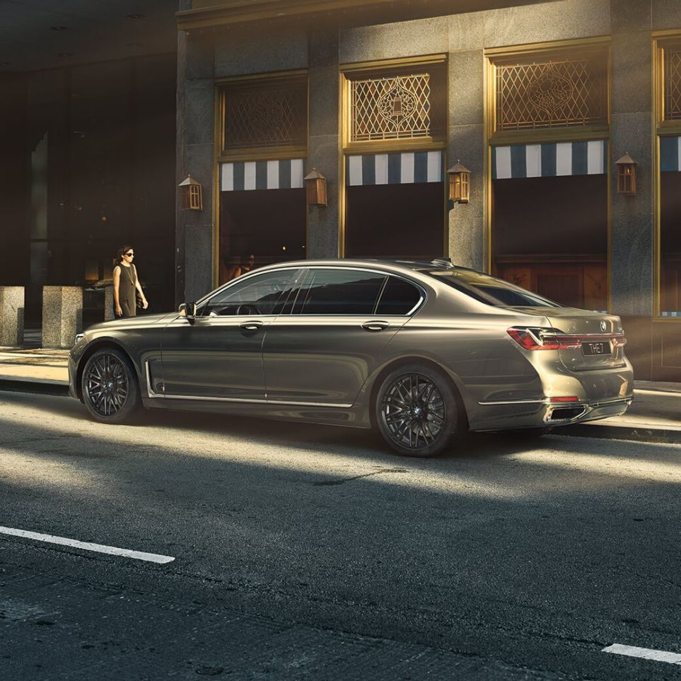 BMW M760Li xDrive с двигателем V12 BMW M760Li xDrive: вид сзади сбоку на фоне городских небоскребов