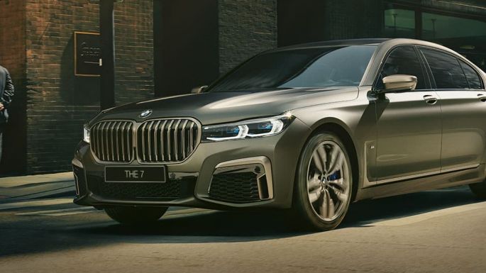 BMW M760Li xDrive в городе BMW M760Li xDrive: в движении по городским улицам, вид сзади сбоку