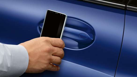 Цифровой ключ BMW Digital Key BMW 8 серии Coupe G15 LCI Facelift 2022 Цифровой ключ BMW Digital Key BMW 8 серии Coupe G15 LCI Facelift 2022, M Синий Портимау металлик, рука со смартфоном перед дверью автомобиля