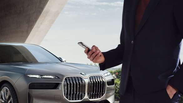 BMW i7 G70, цифровой ключ Digital Key Plus BMW i7 G70, цифровой ключ Digital Key Plus, смартфон перед дверью автомобиля