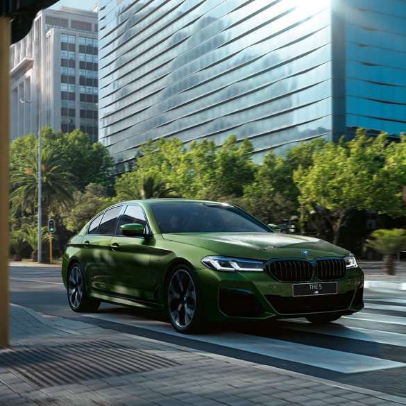 BMW M550i xDrive G30 LCI Facelift 2020, вид вид спереди в три четверти, в движении BMW M550i xDrive G30 LCI Facelift 2020, BMW Individual "Зеленый Эрмес металлик", на городской улице, вид спереди в три четверти