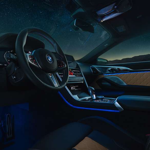 BMW M8 Competition Купе, кокпит F92. BMW M8 Competition Купе, кокпит с обтянутым кожей рулевым колесом M и фоновой подсветкой синего цвета в темное время суток F92.