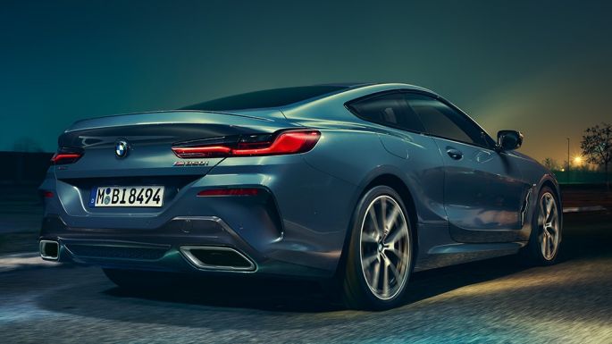 BMW M850i xDrive Coupe, вид сзади. BMW M850i xDrive Coupe, Синий Барселона металлик, вид сзади, автомобиль в движении в темное время суток.