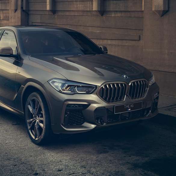 BMW X6 M50i с 8-цилиндровым бензиновым двигателем M TwinPower Turbo BMW X6 M50i G06 с 8-цилиндровым бензиновым двигателем M TwinPower Turbo в цвете Manhattan (металлик), вид сбоку с поворотом в три четверти