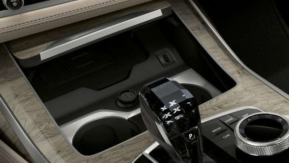 Подстаканники с регулировкой температуры автомобиля BMW X7 M Автомобиль BMW X7 M, салон, крупный план центральной консоли с фокусировкой на подстаканниках с регулировкой температуры, G07