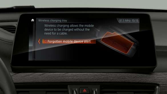 BMW X1, телефония с возможностью беспроводной зарядки. BMW X1, фотография интерьера с акцентом на ассистент вождения Plus – дисплеи и органы управления.