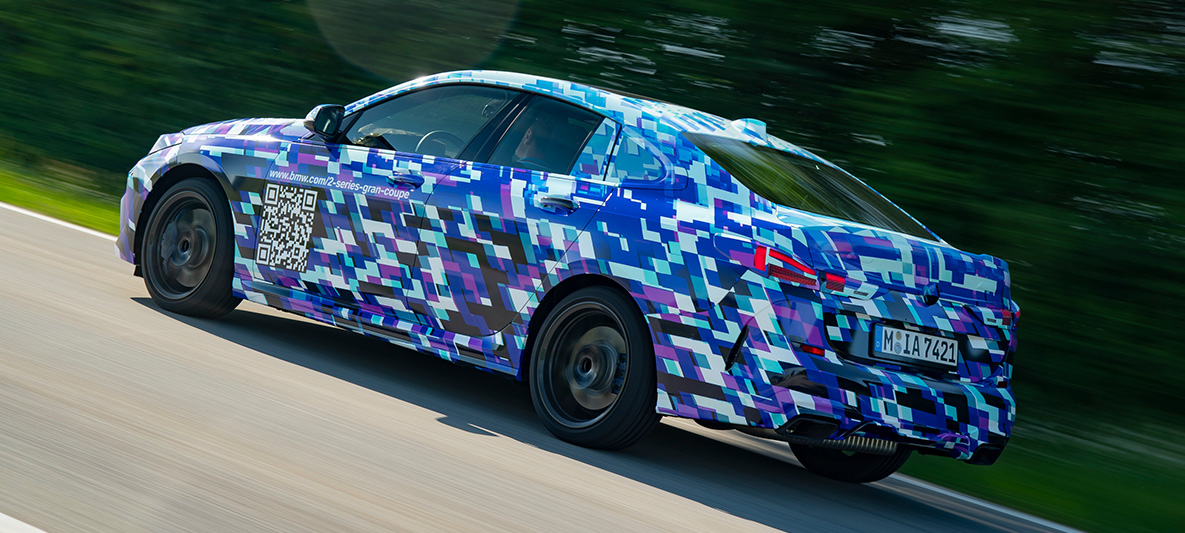 Динамические характеристики BMW 2 серии Gran Coupe BMW M235i xDrive 2020: вид закамуфлированного прототипа сбоку с поворотом в три четверти