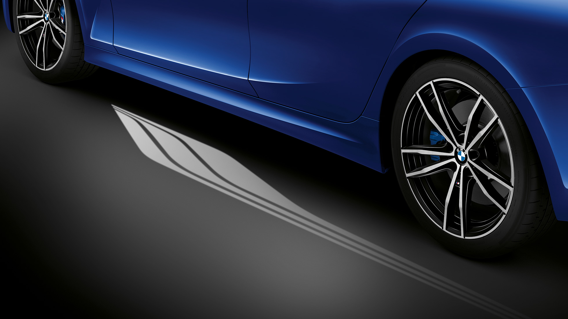 Седан BMW 3 серии, подсветка Welcome light Вид спереди места водителя седана BMW 3 серии с подсветкой Ambient light синего цвета пространства для ног.