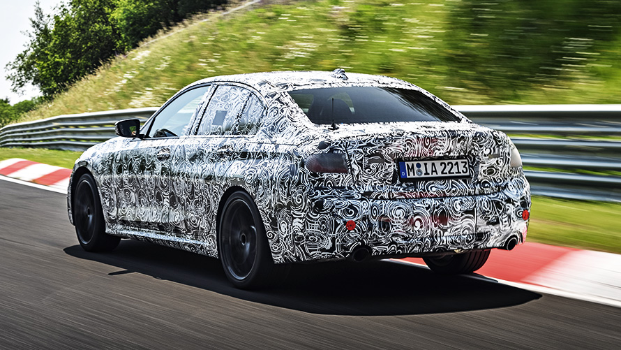 BMW 3 серии в движении. Закамуфлированный прототип BMW 3 в повороте гоночной трассы.