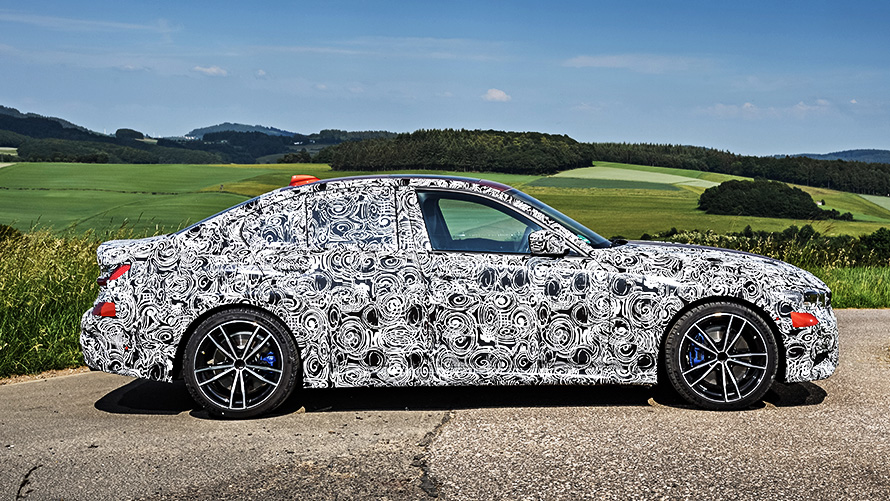 BMW 3 серии в движении. Закамуфлированный прототип BMW 3 серии на гоночной трассе, вид сбоку