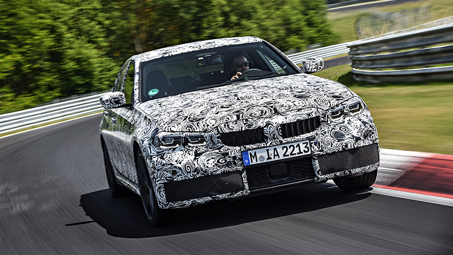BMW 3 серии в движении. Вид спереди закамуфлированного прототипа BMW 3 серии на гоночной трассе.