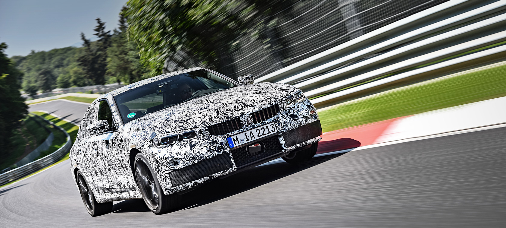 BMW 3 серии в движении. Закамуфлированный прототип BMW 3 серии в повороте гоночной трассы.