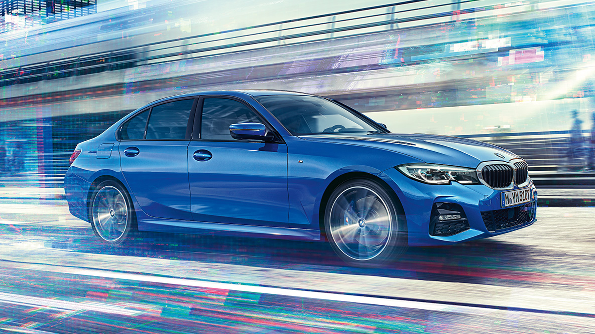 BMW 3 серии (G20), вид сбоку в движении. Вид сбоку BMW 3 серии (G20) днем на урбанистическом фоне.