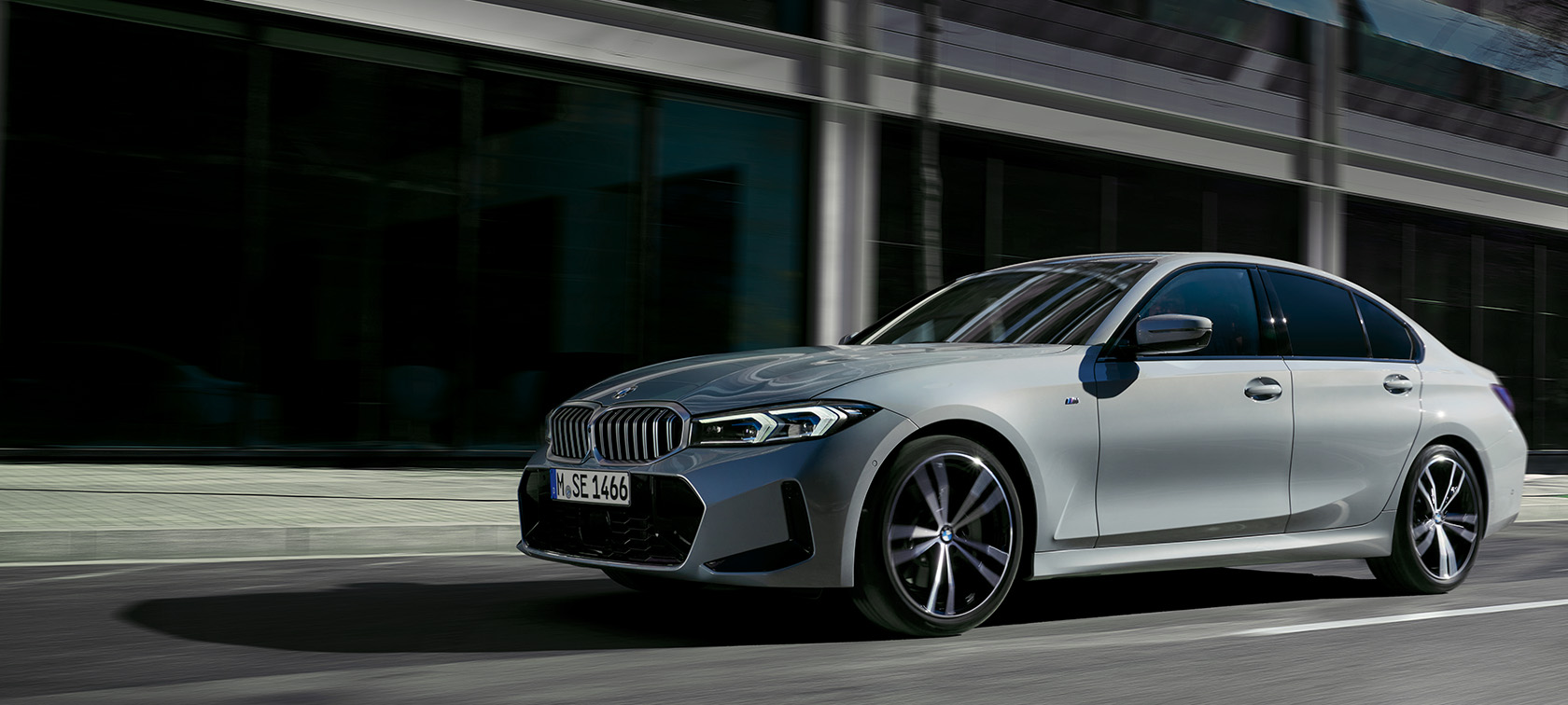 BMW 3 серии LCI G20, "M Серый Бруклин", вид сбоку в статике перед стеной