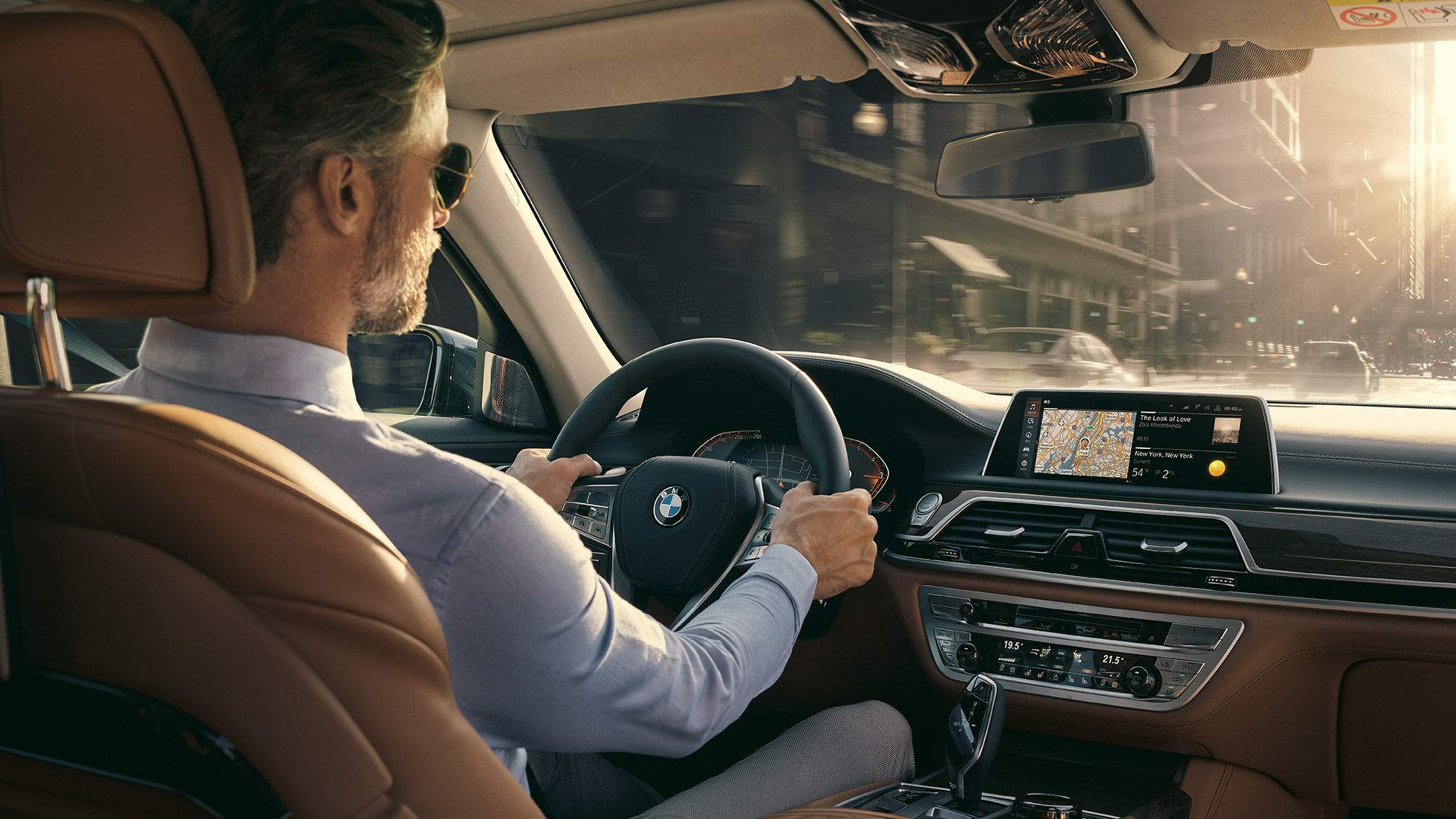 Седан BMW 7 серии: возможности подключения G11 BMW 7 серии: мужчина использует возможности подключения BMW G11