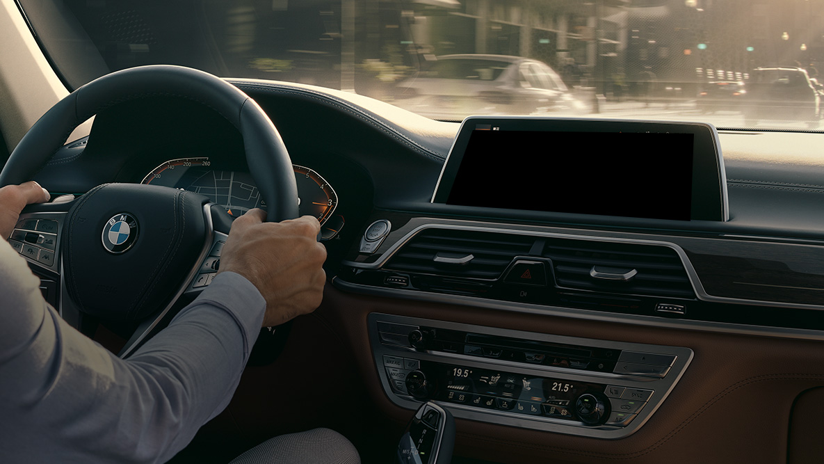 Умный помощник BMW Intelligent Personal Assistant G11 Умный помощник BMW Intelligent Personal Assistant: мужчина управляет автомобилем BMW, крупный план приборной панели Live Cockpit Professional G11