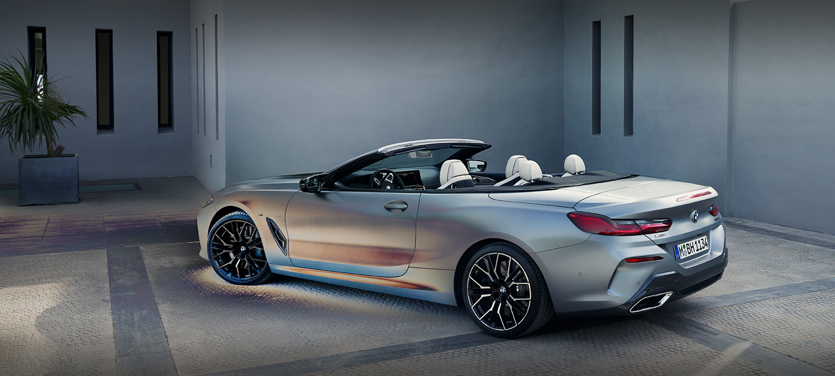 Мужчина рядом с BMW 8 серии Cabrio G14 LCI Facelift 2022, BMW Individual Морозный Чистый Серый металлик, вид сбоку в статике перед зданием, вместе с мужчиной