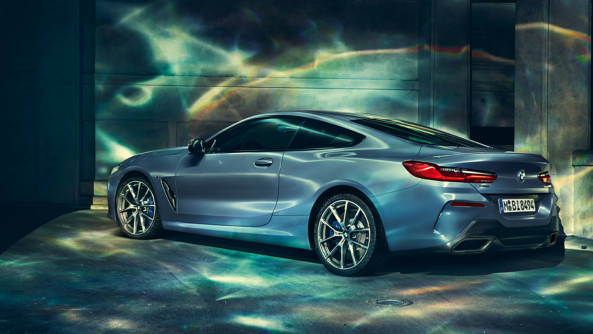 BMW 8 серии, вид спереди с поворотом в три четверти BMW 8 серии Coupe в городе, вид спереди с поворотом в три четверти.