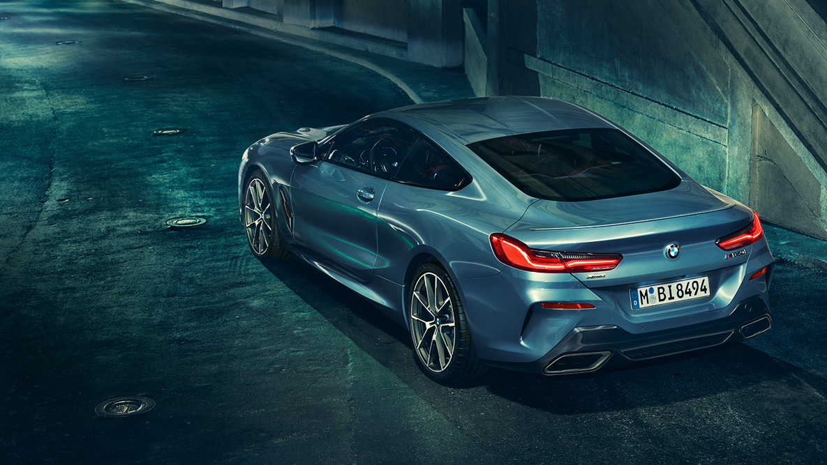 BMW 8 серии Coupe, вид сзади с поворотом в три четверти BMW 8 серии Coupe в ночном городе, вид сзади с поворотом в три четверти.