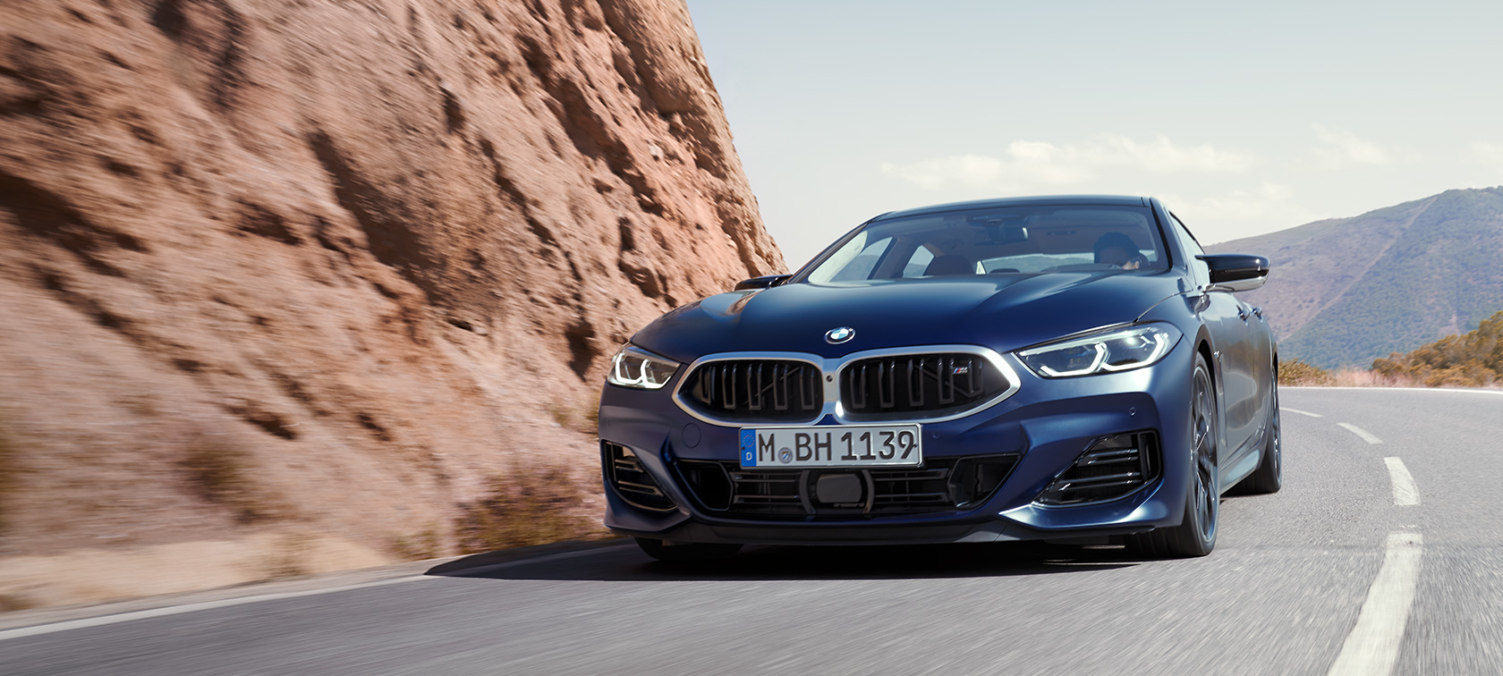 BMW 8 серии Gran Coupe G16 LCI Facelift 2022, BMW Individual Морозный Синий Танзанит металлик, вид спереди в три четверти в движении на горной дороге