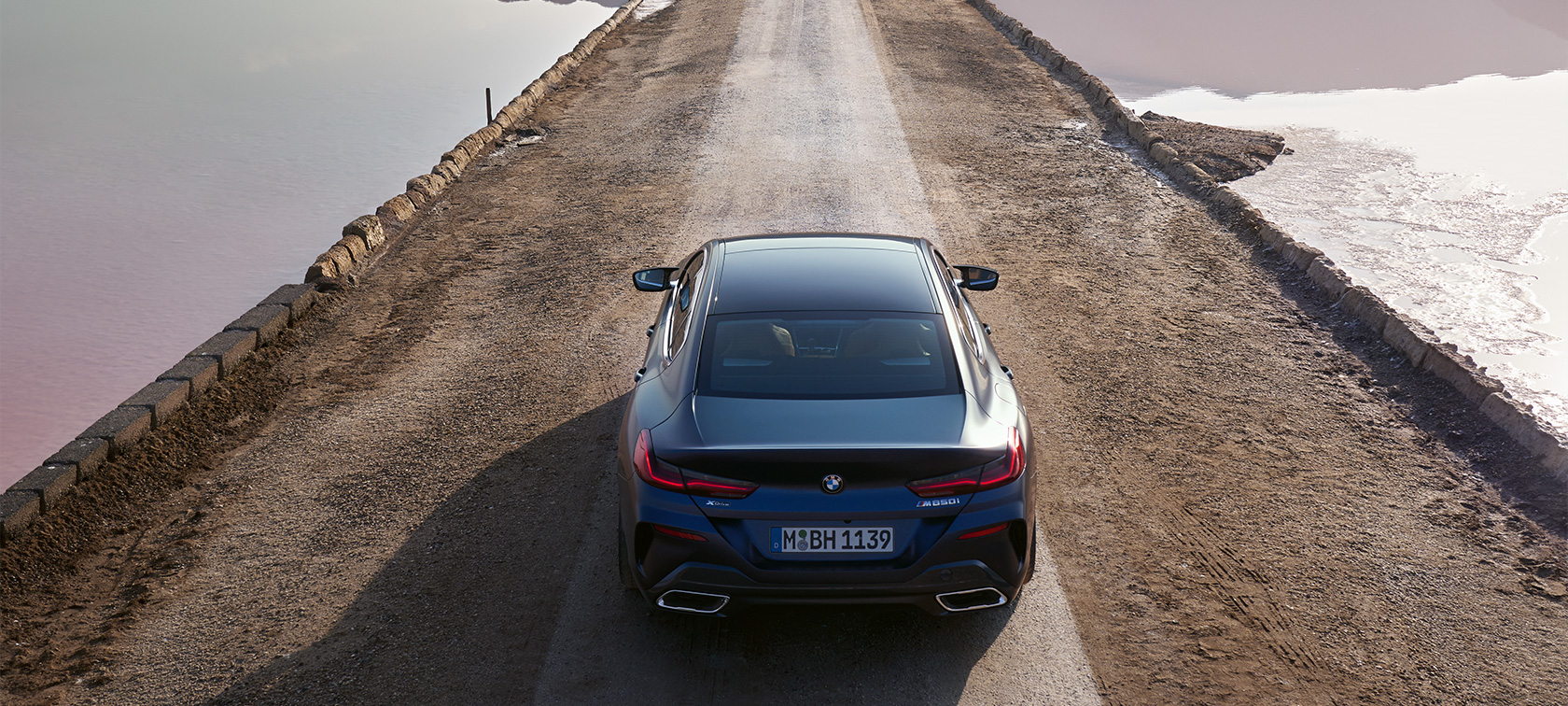 BMW 8 серии Gran Coupe G16 LCI Facelift 2022, BMW Individual Морозный Синий Танзанит металлик, вид сбоку в три четверти в статике перед зданием BMW 8 серии Gran Coupe G16 LCI Facelift 2022, BMW Individual Морозный Синий Танзанит металлик, вид сбоку в три четверти в статике перед зданием