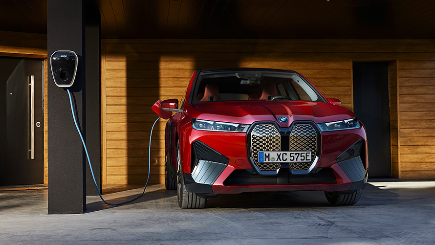 Электрический SUV BMW iX i20, зарядка BMW iX xDrive50 Электрический SUV BMW iX i20 2021, BMW iX xDrive50 "Красный Авантюрин" заряжается устройством BMW Wallbox, зарядка