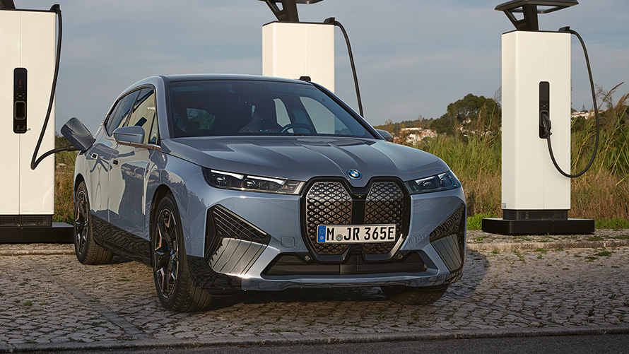 BMW iX M60 i20 2022, электрический SUV, BMW Individual Серый Шторм Бэй металлик, вид спереди, на высокомощной зарядной станции