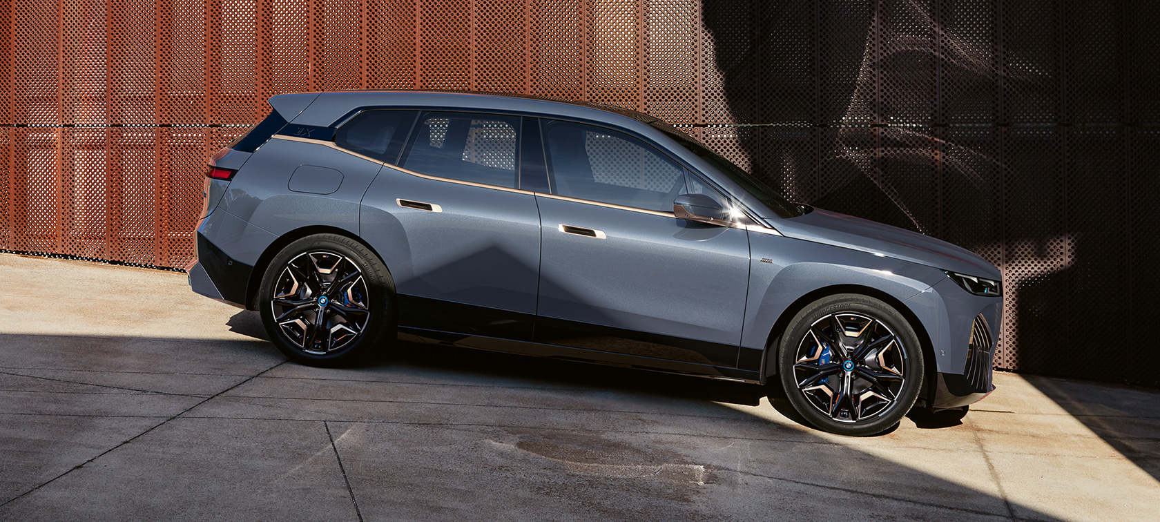 BMW iX M60 i20 2022, электрический SUV, BMW Individual Серый Шторм Бэй металлик, вид сбоку при парковке
