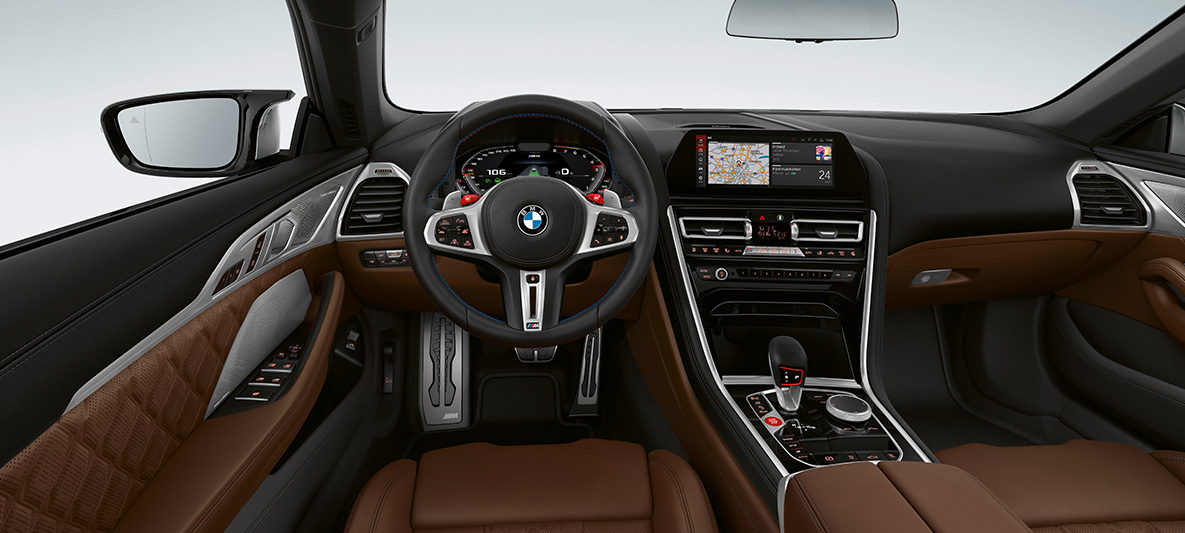 BMW M8Cabrio, кокпит. BMW M8Cabrio, кокпит с обтянутым кожей рулевым колесом M с кнопками M1/M2 красного цвета.