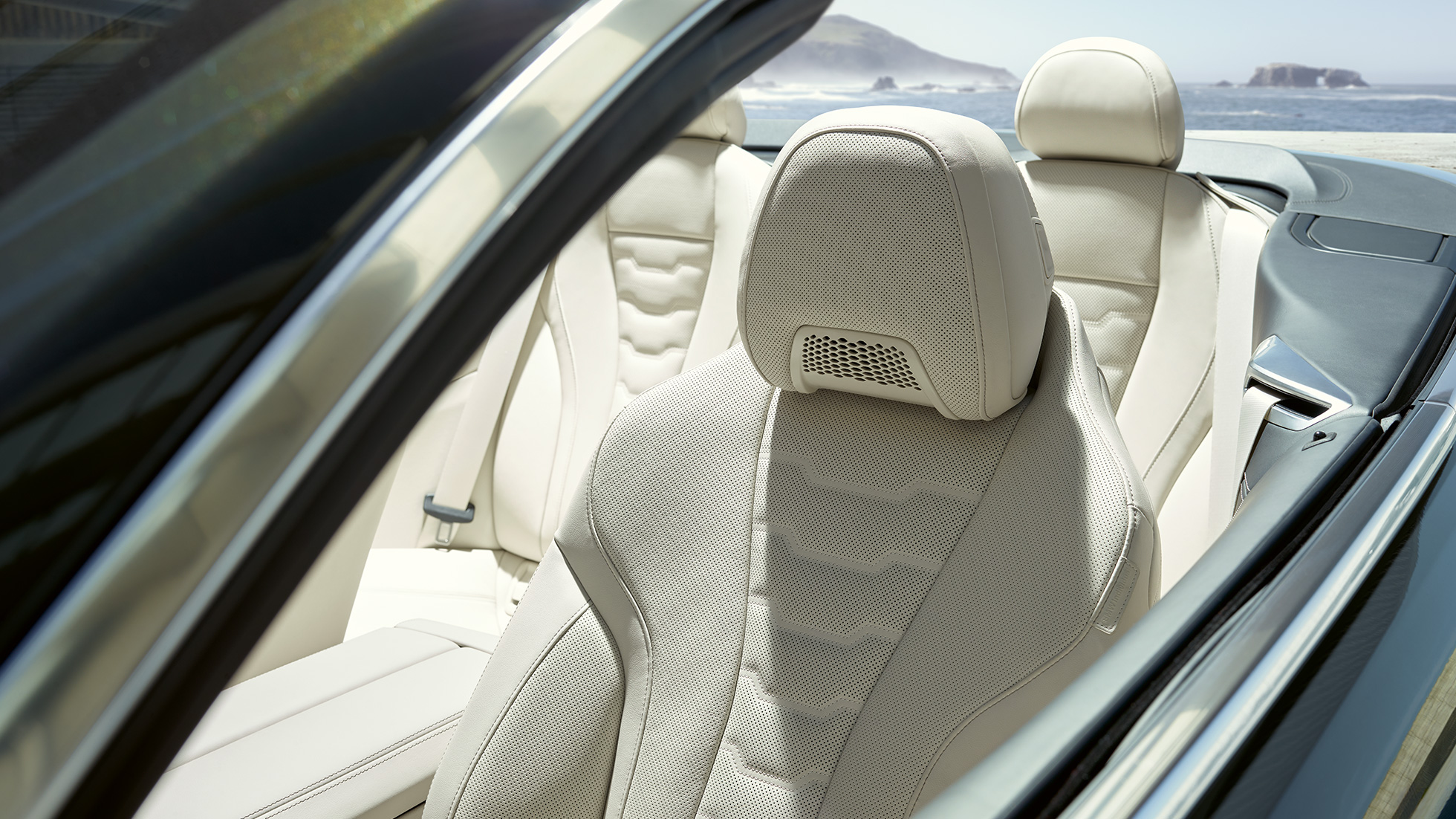 BMW M850i xDrive Cabrio, многофункциональные сиденья водителя и пассажира. BMW M850i xDrive Cabrio с открытым мягким верхом, Серый Дравит металлик, интерьер с акцентом на многофункциональные сиденья с отделкой кожей Merino BMW Individual цвета «Слоновая Кость».
