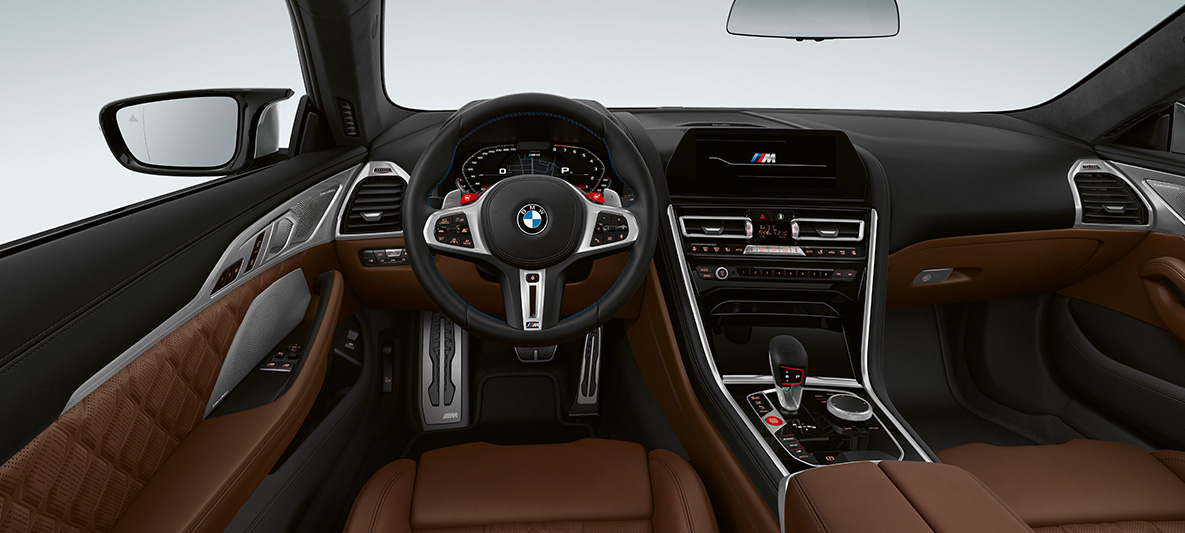 BMW M8 Coupe, кокпит. BMW M8 Coupe, кокпит с обтянутым кожей рулевым колесом M с кнопками M1/M2 красного цвета.