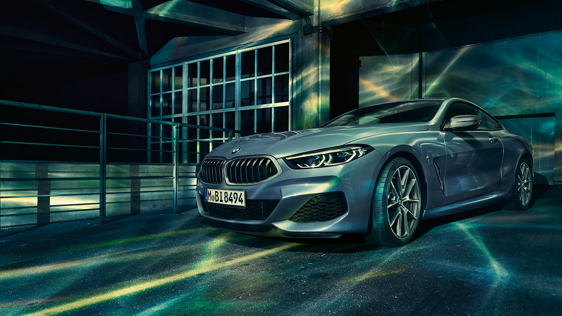 BMW M850i xDrive Coupe, вид спереди с поворотом в три четверти. BMW M850i xDriveCoupe, Синий Барселона металлик, вид спереди с поворотом в три четверти, неподвижный автомобиль перед зданием.
