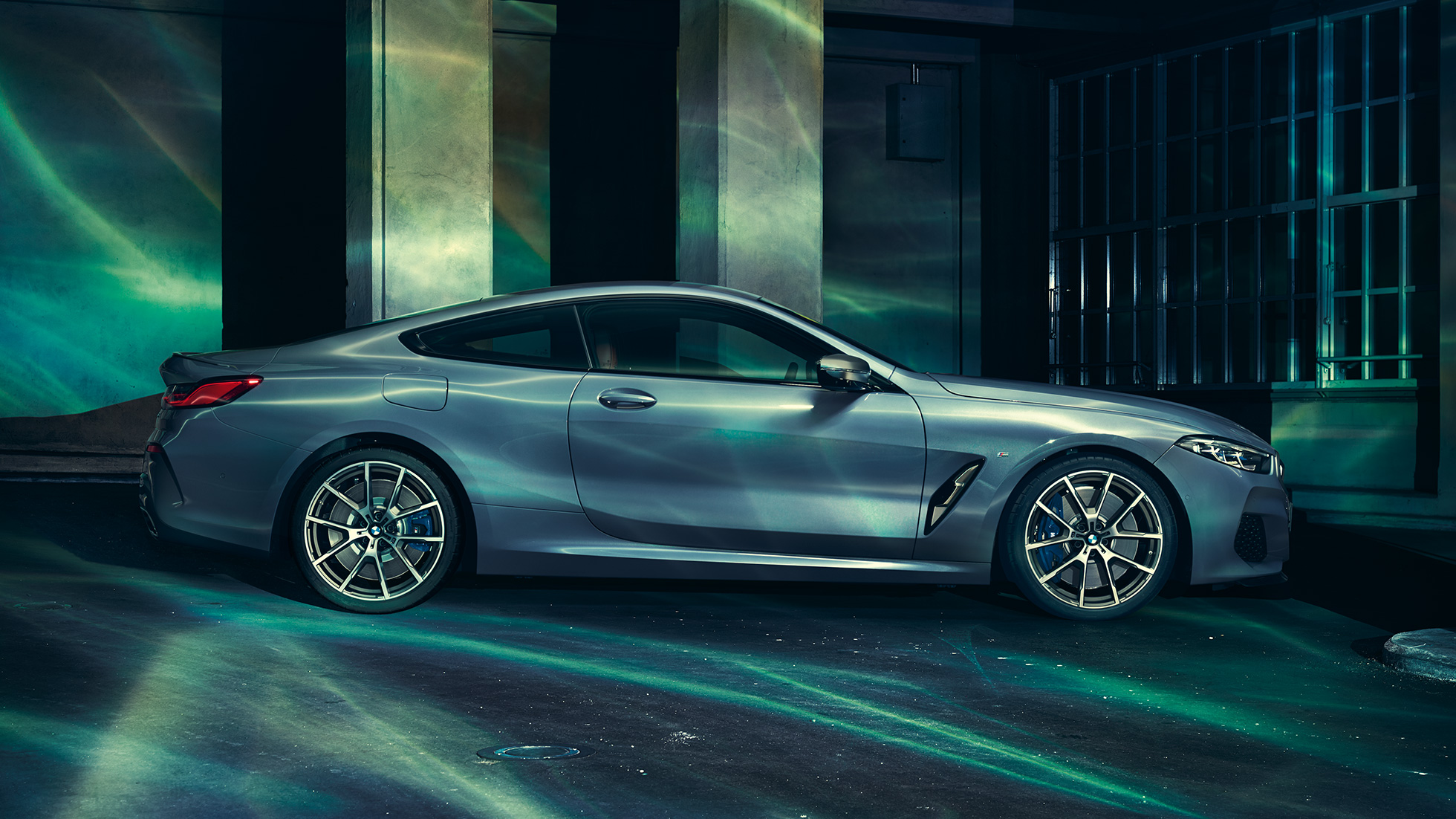 BMW M850i xDriveCoupe, вид сбоку. BMW M850i xDriveCoupe, Синий Барселона металлик, вид сбоку, неподвижный автомобиль перед зданием.