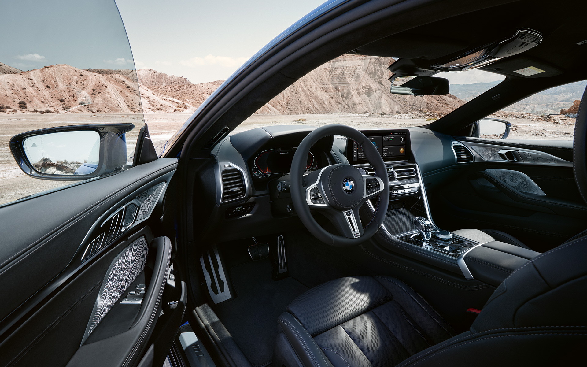 BMW M850i xDrive Coupe G15 LCI Facelift 2022, ориентированный на водителя кокпит с кожаным рулевым колесом M BMW M850i xDrive Coupe G15 LCI Facelift 2022, ориентированный на водителя кокпит с кожаным рулевым колесом M и открытой передней дверью
