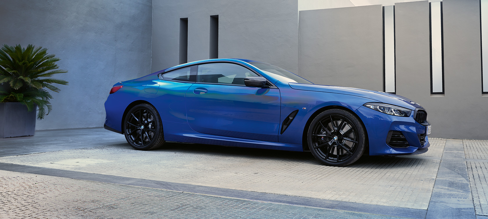 Вид сбоку BMW M850i xDrive Coupe G15 LCI Facelift 2022 BMW M850i xDrive Coupe G15 LCI Facelift 2022, M Синий Портимау металлик, вид сбоку перед зданием