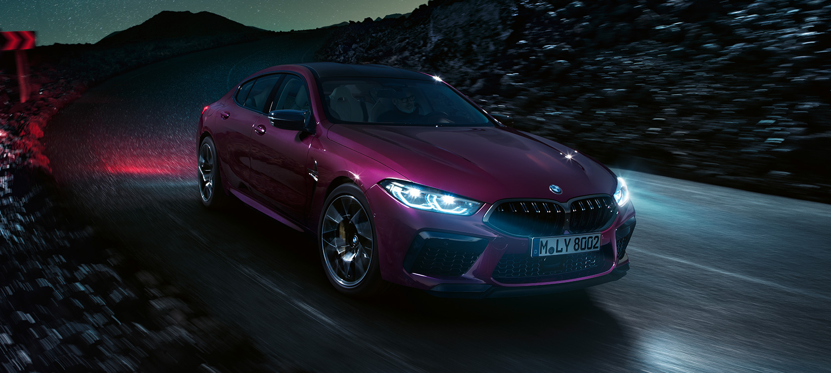 BMW M8 Competition Gran Coupe, вид спереди с поворотом в три четверти BMW M8 Competition Gran Coupe F93 2020 МГ цвета Аметрин металлик из линейки BMW Individual, вид спереди с поворотом в три четверти, в движении в ночное время