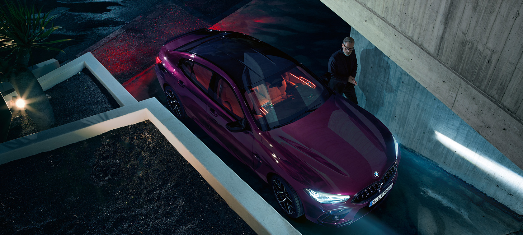 BMW M8 Competition Gran Coupe, вид сверху BMW M8 Competition Gran Coupe F93 2020 МГ цвета Аметрин металлик из линейки BMW Individual перед зданием, вид сверху с поворотом в три четверти
