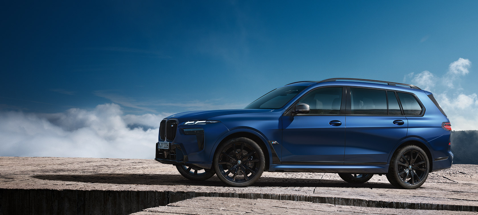 BMW X7 M60i xDrive G07 LCI, Морозный Синий Марина Бэй металлик, вид сбоку в статике на фоне горного пейзажа