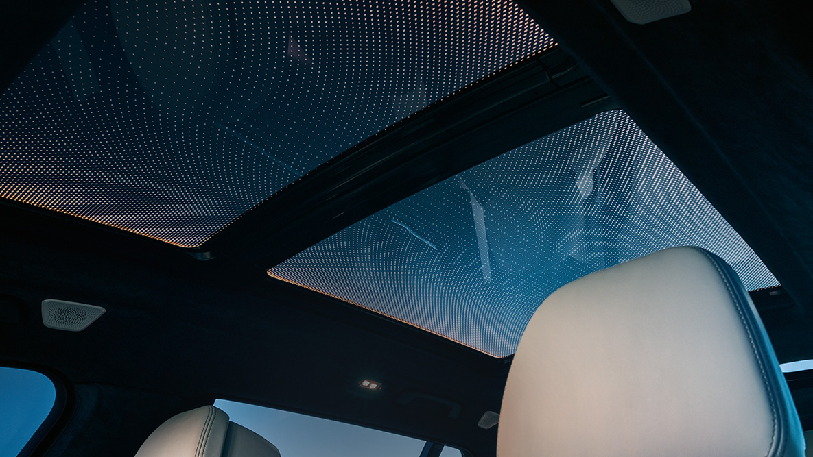 Подсветка Ambient light Вид с первого ряда сидений на панорамную стеклянную крышу с оранжевой окантовкой подсветки Ambient light