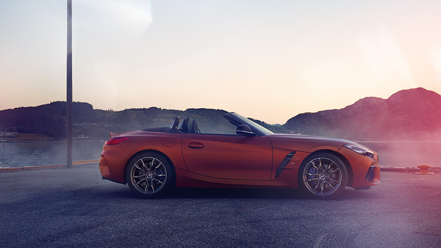 BMW Z4 First Edition красного цвета стоит на повороте дороги BMW Z4 First Edition красного цвета стоит на повороте дороги на фоне горного пейзажа