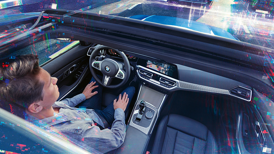 BMW Personal CoPilot: интеллектуальная парковка Мужчина находится в автомобиле BMW, который паркуется с использованием парковочного ассистента BMW Personal CoPilot.