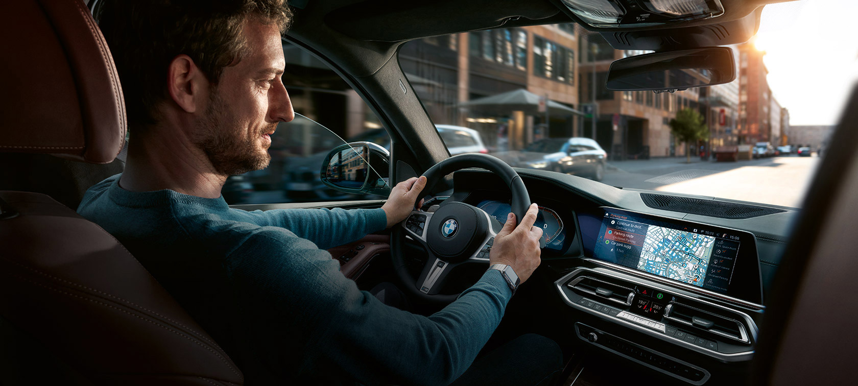 Мужчина едет на BMW с навигацией BMW Maps на центральном дисплее