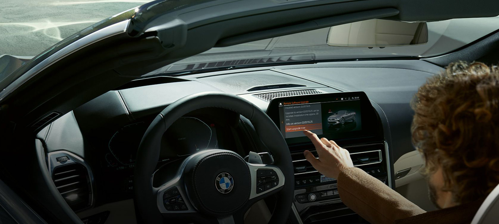 BMW Remote Software Upgrade Мужчина сидит в BMW и запускает BMW Remote Software Upgrade