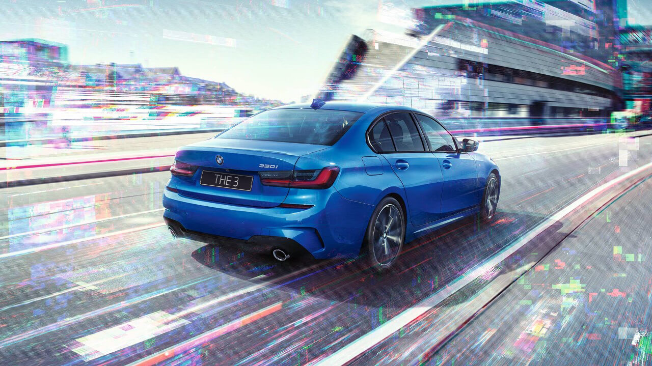 Седан BMW 3 серии, вид сзади сбоку G20 Седан BMW 3 серии, вид сзади с поворотом в три четверти, в дневное время на фоне города G20.