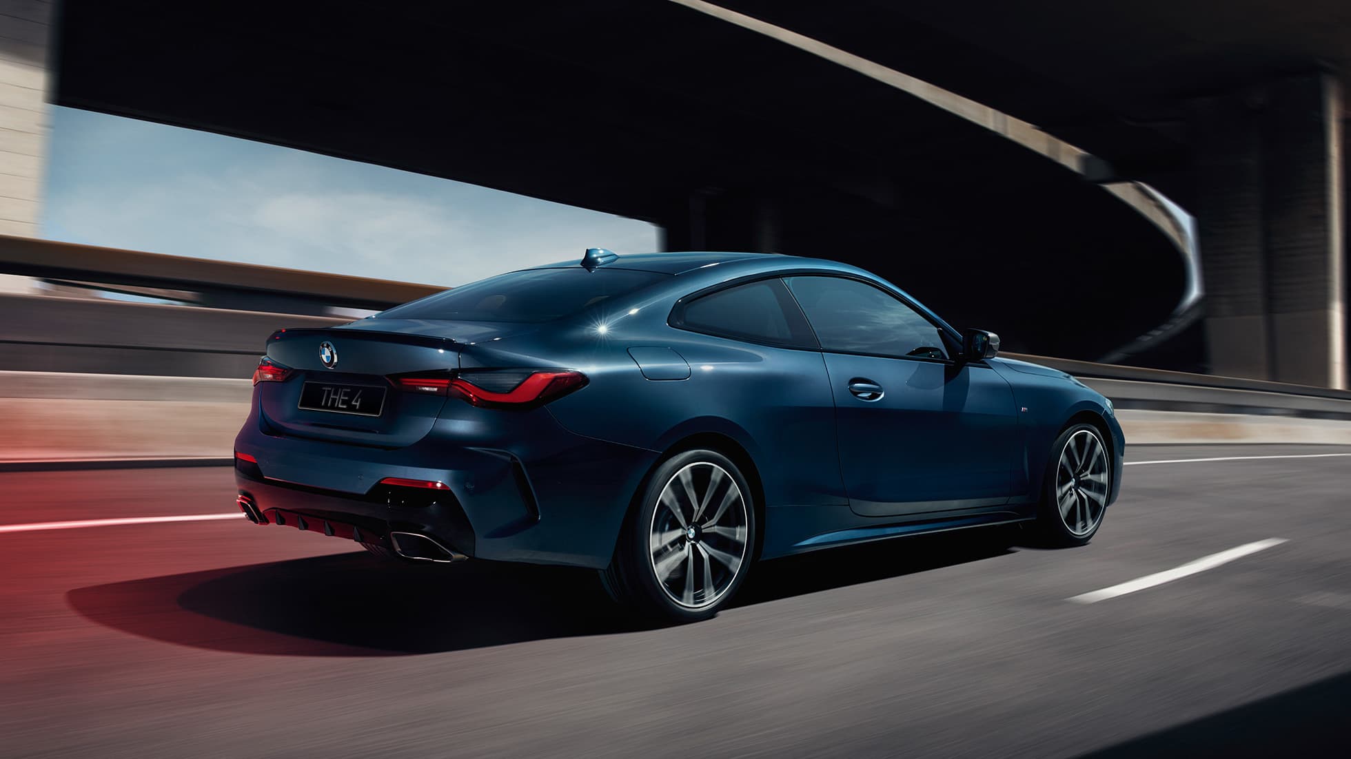 Вид модели BMW 4 серии Coupe G22 2020 года сбоку с поворотом в три четверти BMW 4 серии Coupe G22 2020 года, цвет «Синий Арктик Рэйс Арктик Рэйс» металлик, вид сбоку в движении с поворотом в три четверти