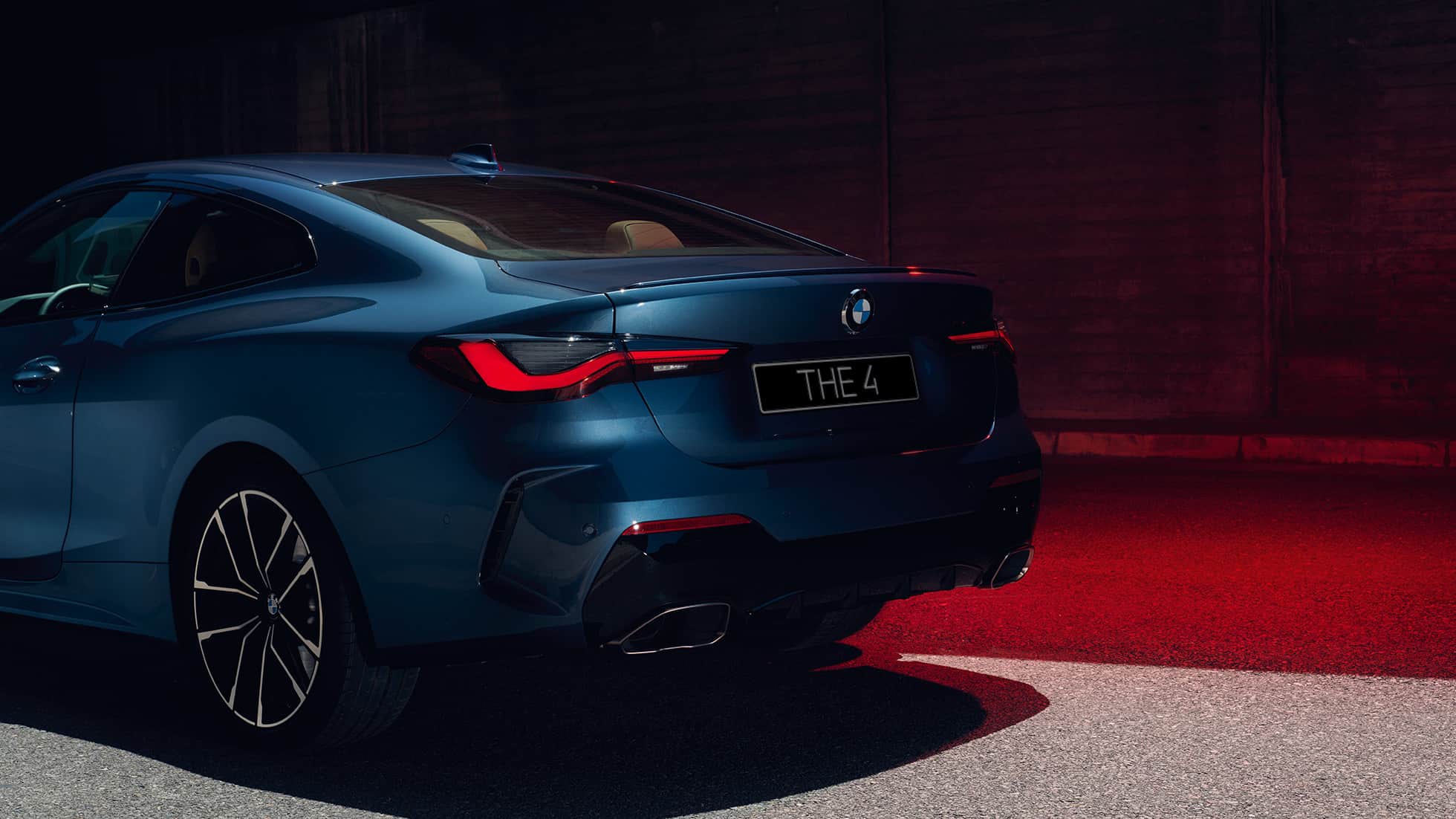 Вид модели BMW 4 серии Coupe G22 2020 года сзади с поворотом в три четверти, патрубки системы выпуска BMW 4 серии Coupe G22 2020 года, цвет «Синий Арктик Рэйс» металлик, вид сзади с поворотом в три четверти, патрубки системы выпуска