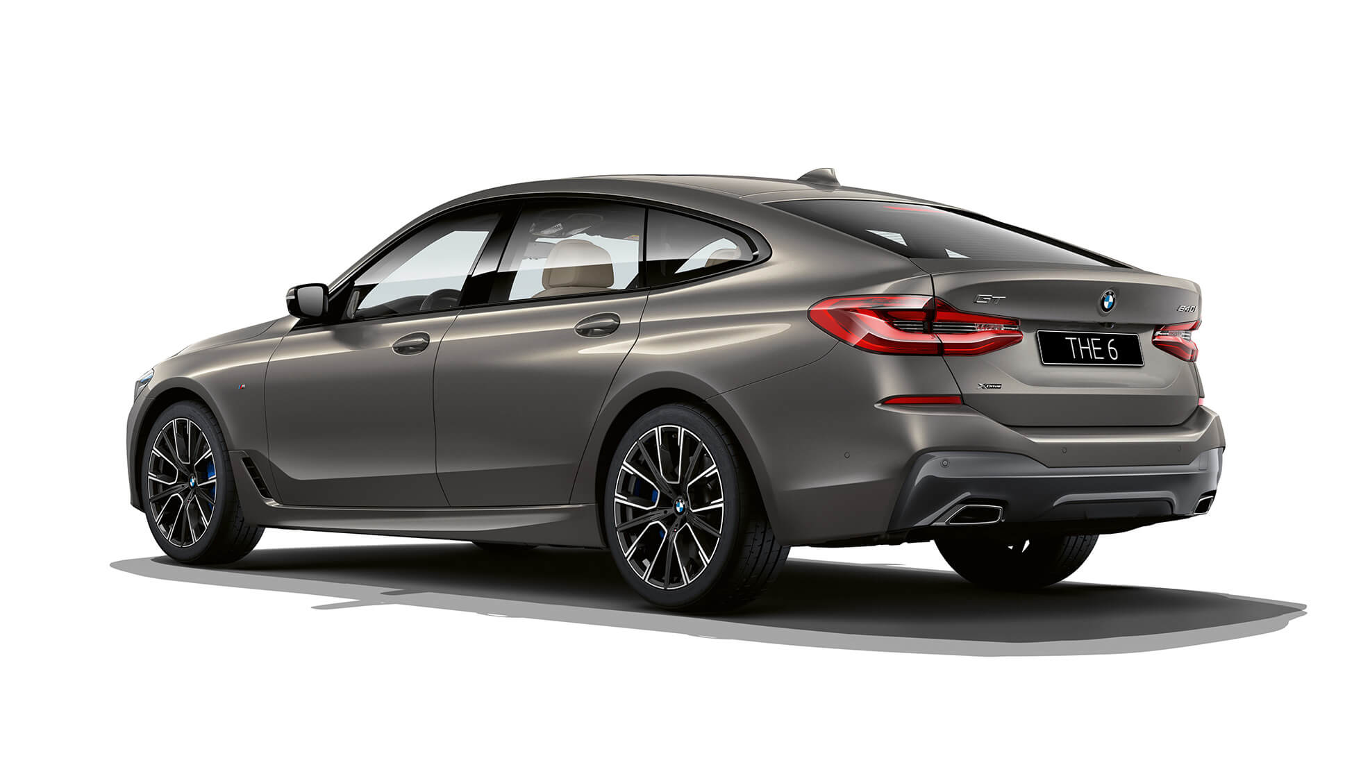 Задняя часть кузова BMW 6 серии GT G32 2020 года с пакетом M Sport BMW 6 серии GT G32 640i xDrive 2020 года с пакетом M Sport, цвет «Серый Бернина» с эффектом янтарного мерцания, вид сзади с поворотом в три четверти
